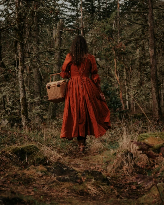 a woman wearing red standing in the woods