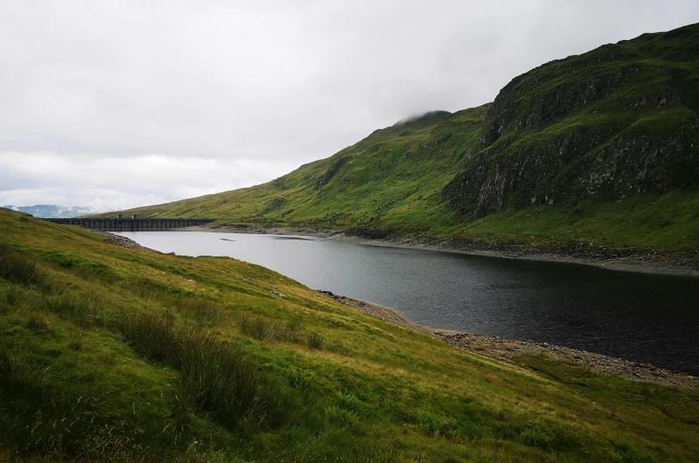 an empty river with grass and hills surrounding it