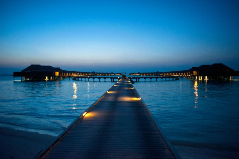 there is a pier that runs into the water and some buildings