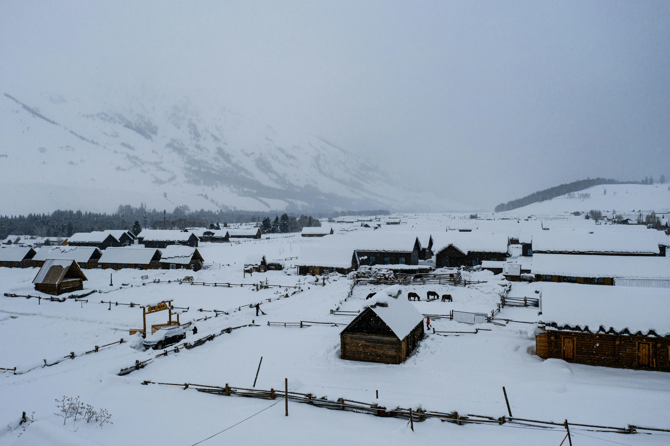 a large snow covered town with a tall mountain