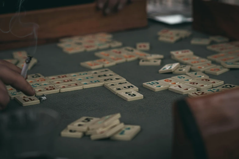 someone is making dominos on a blackboard with white letters