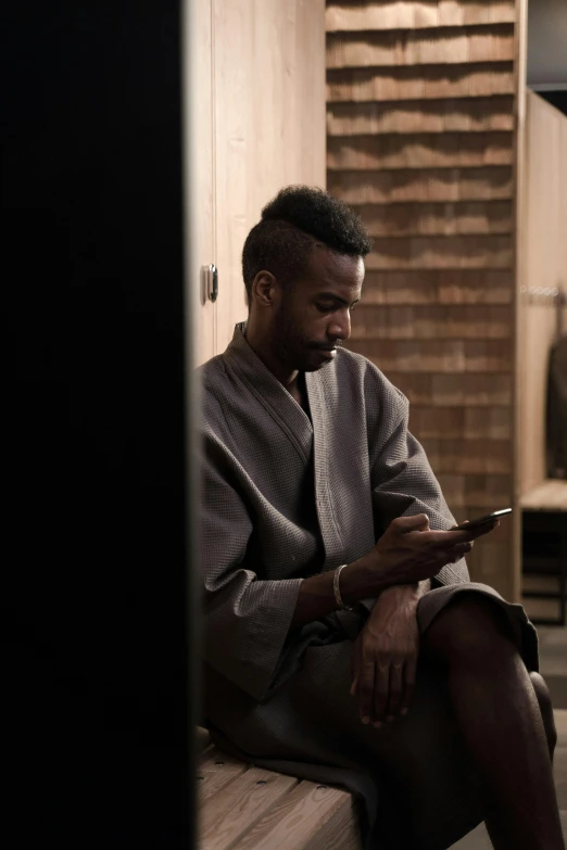 a man sitting on a bench holding a cell phone