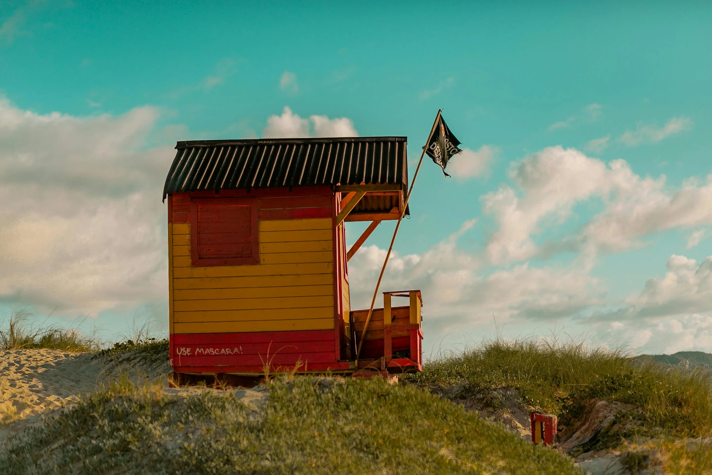 small colorful house on top of an off - ramped hill