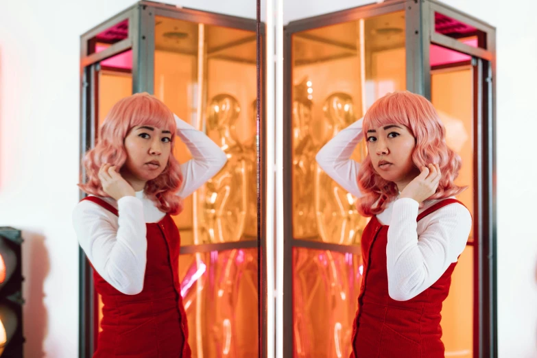 two women that are standing in front of a mirror