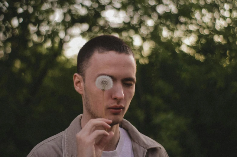 a young man holds an item in his eye