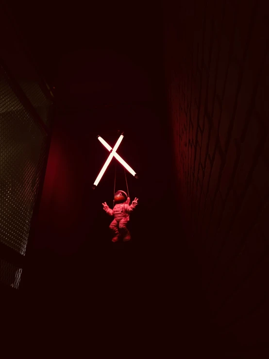 a light up figure holds up two white crosses