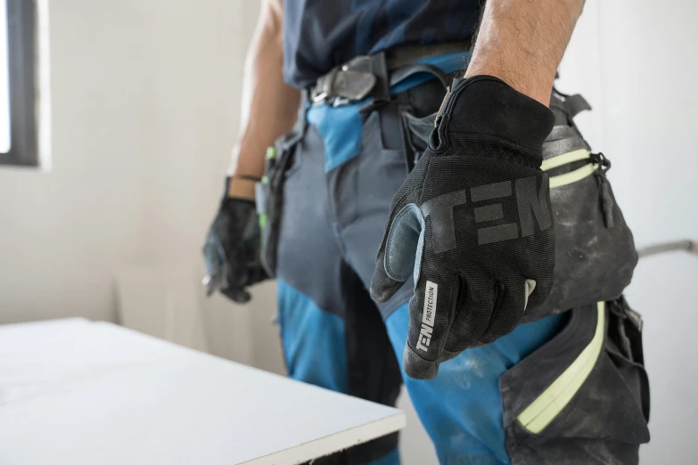 a man wearing work gloves and protective gear