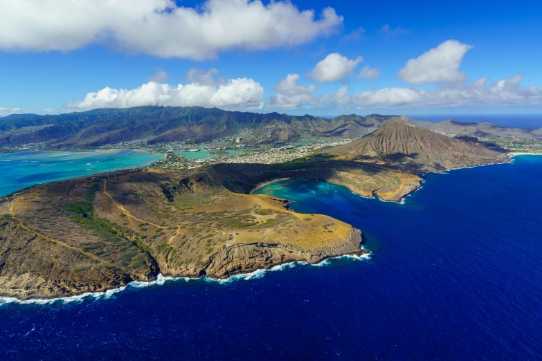 an aerial view of a large island with mountains in the background