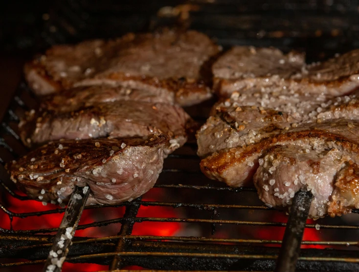 a close up s of steaks on a grill