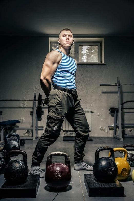 a man posing with kettles and exercise mats on display