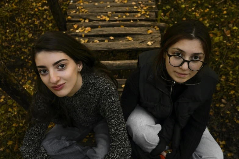 two women sit and smile on a wooden step