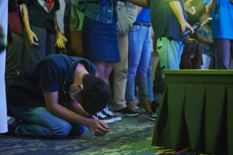 a man with his hand on his knees at the end of a praying ceremony