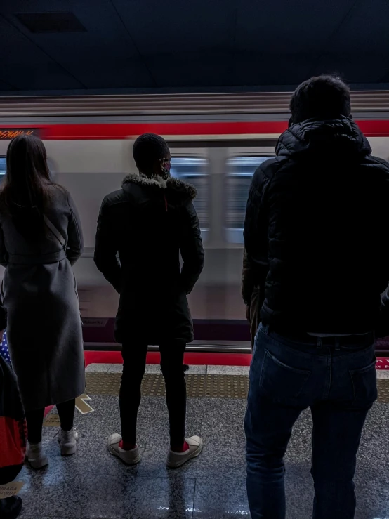 people are standing in front of a train at a station