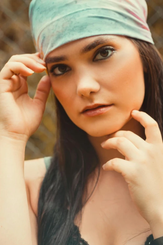 woman wearing a turban standing near chain linked fence