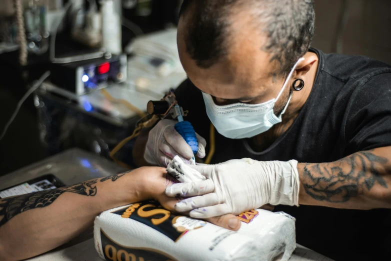 a man getting a tattoo on his foot with a pair of scissors