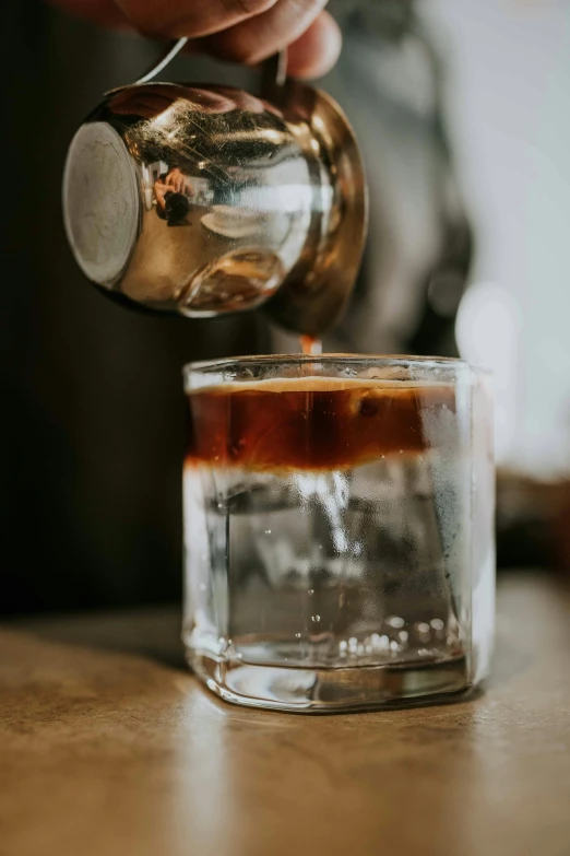 the drink being poured from the pitcher into a glass