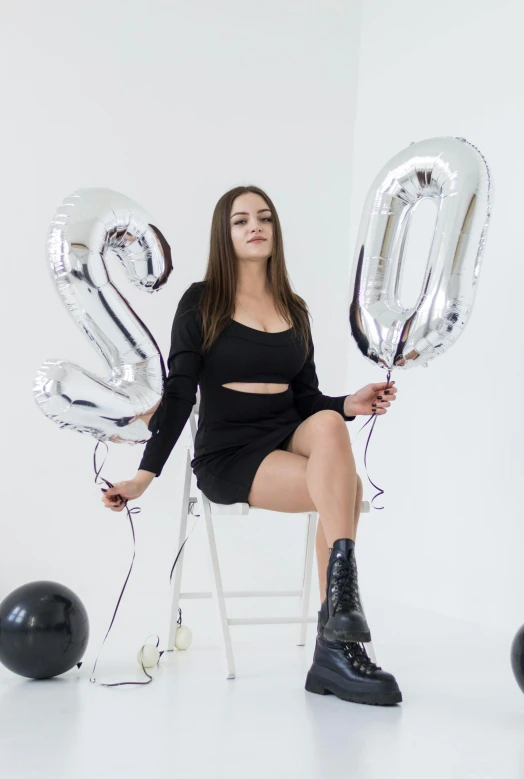 a woman with large silver balloons posing for a po