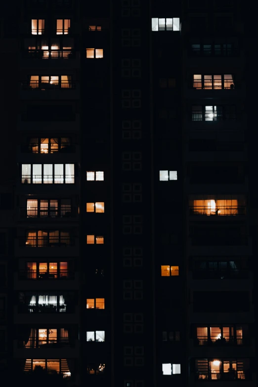 the windows of a tall building lit up at night