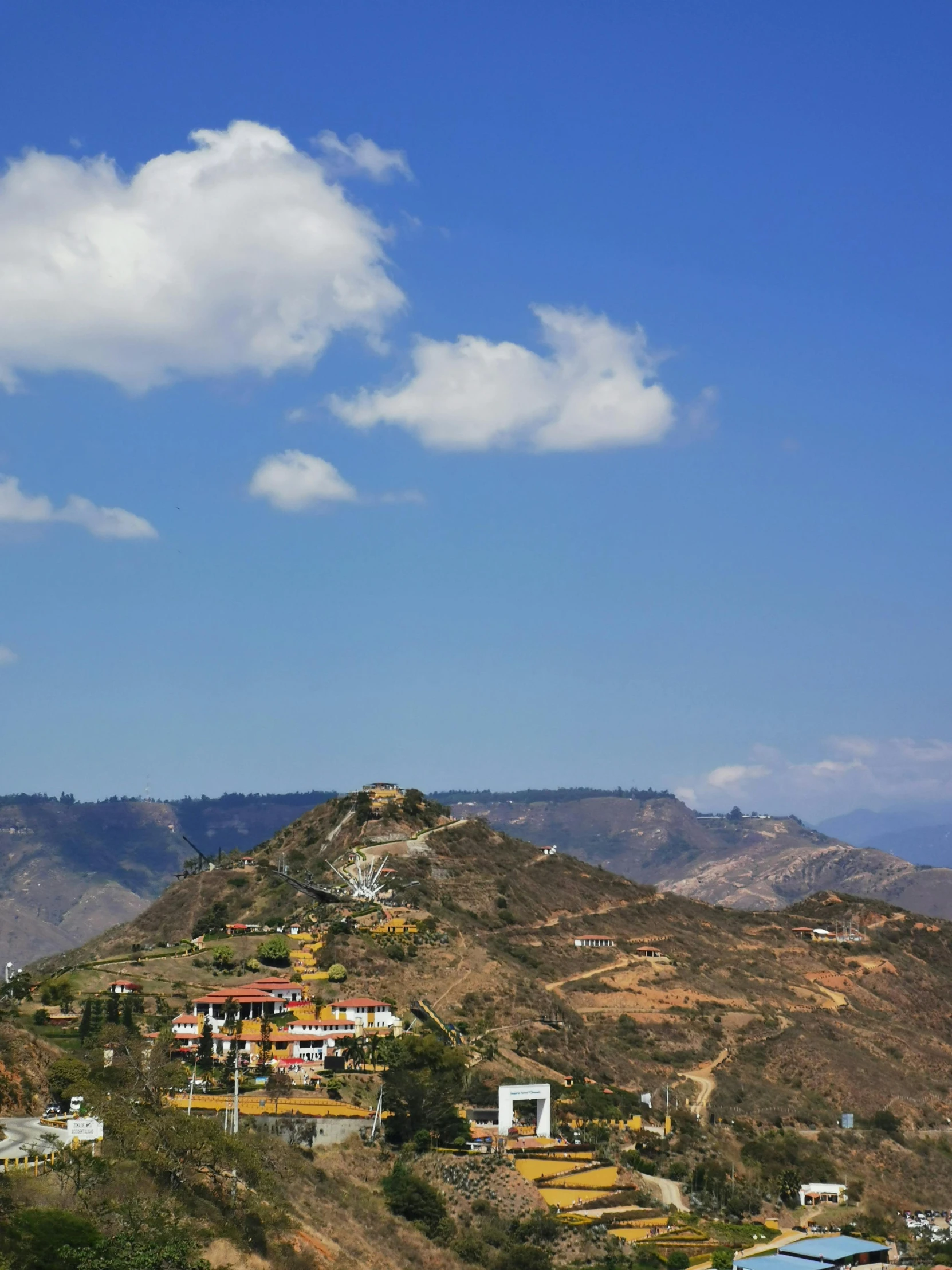 a hill with houses on it with blue sky above