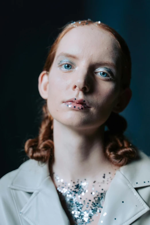 a woman with blue eyes wearing white jewelry