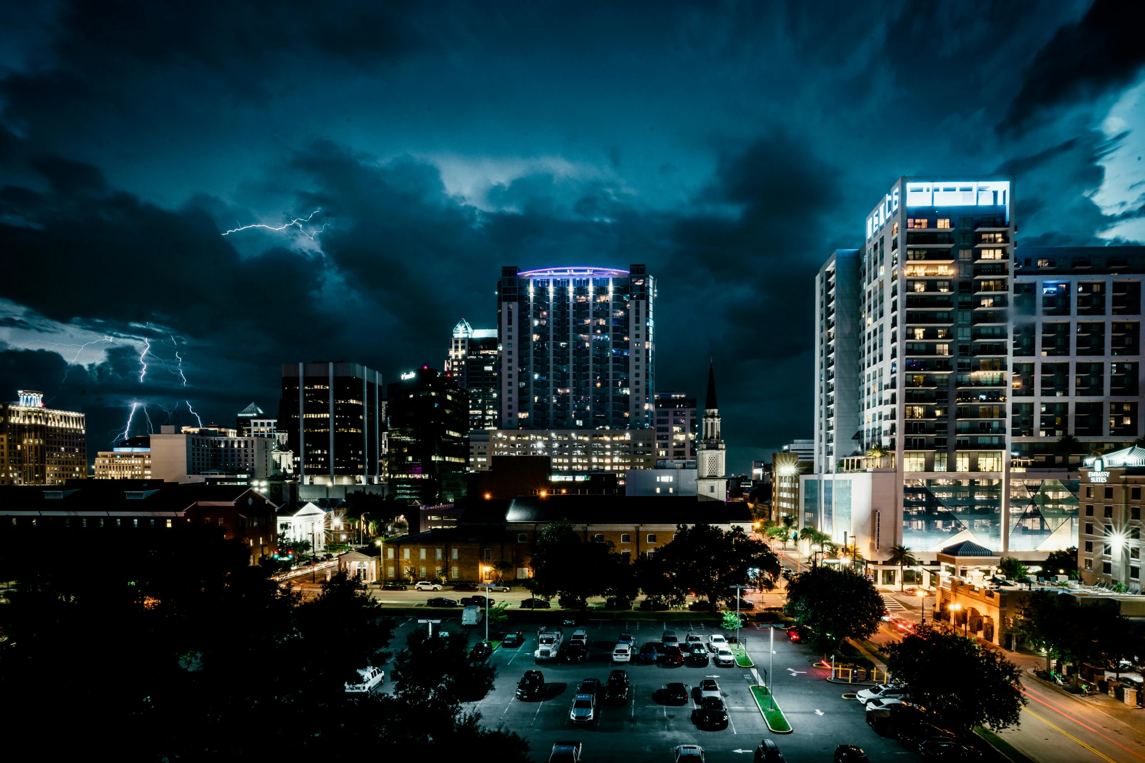 a dark cityscape has cars driving on the street