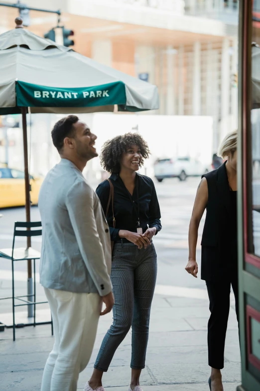 three people walking down the street talking and laughing