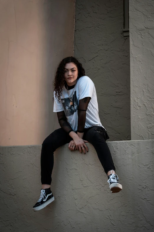 a beautiful woman posing in front of an empty wall