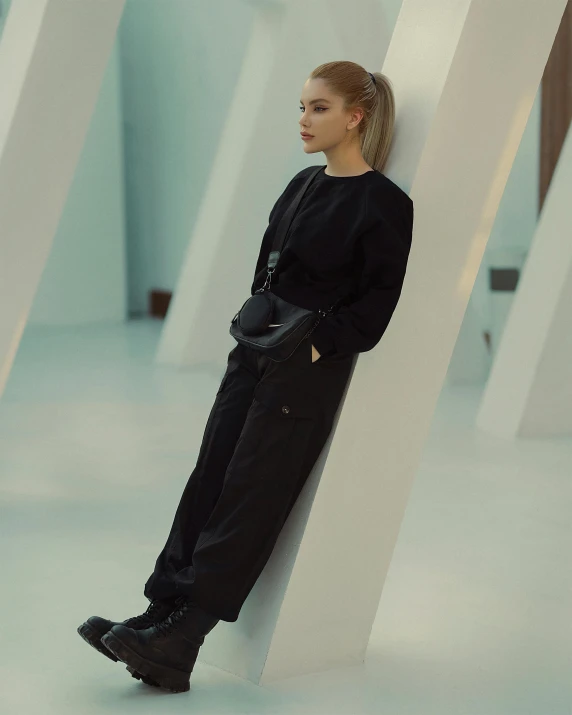 woman leaning against an object in a white room