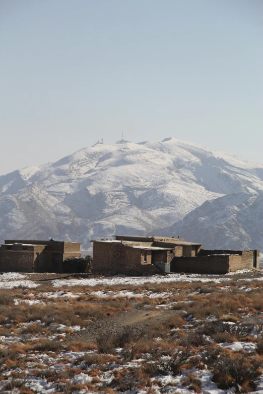 old adobe buildings are sitting in an open field