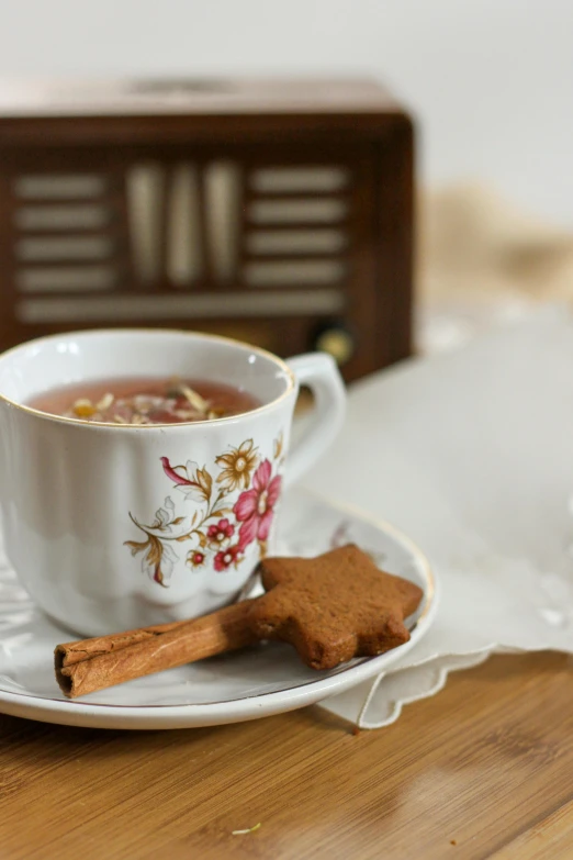 a cup of tea and two cinnamon sticks sit on the table