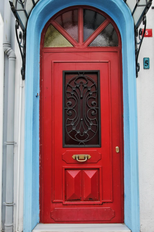 a red door on a grey and blue building