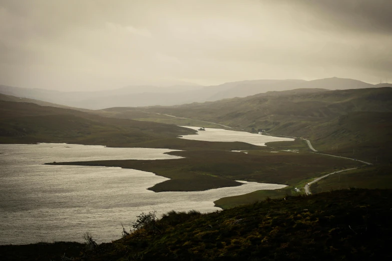 water on hillside with mountains in the background