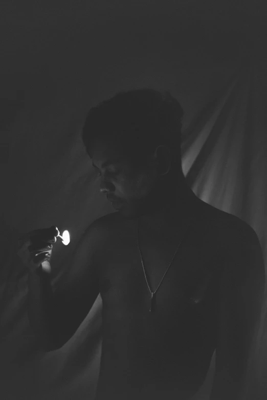 a person stands in a dark room holding a cellphone