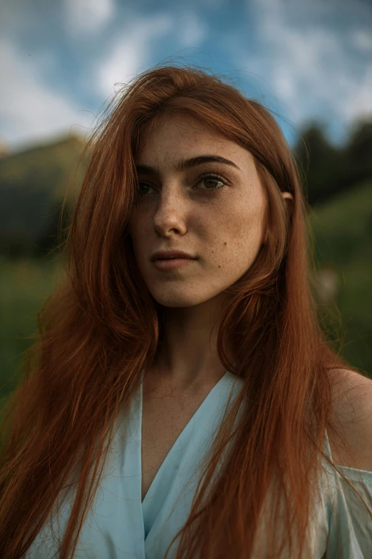 a red haired woman stands outside in a po