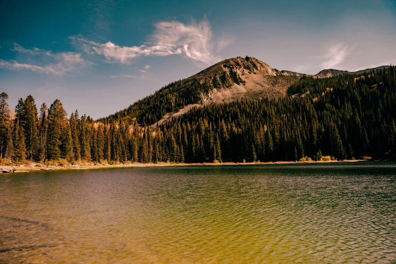 a mountain range sits in the background near a lake