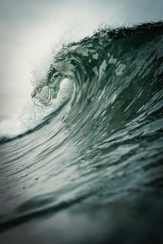 a wave is breaking above the water on the beach