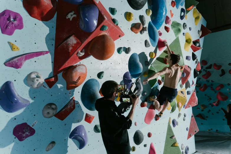 two boys climbing up and down a climbing wall