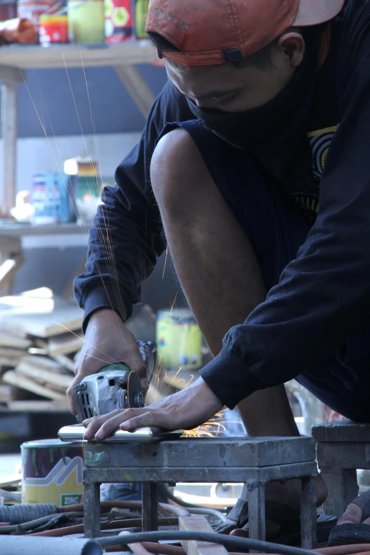 the man is using a circular saw to cut boards