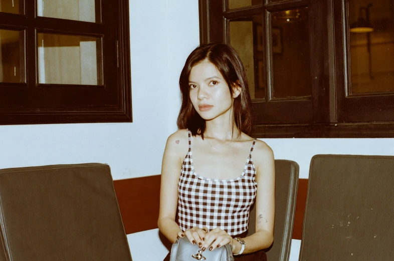 a young woman is sitting with her handbag