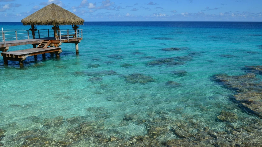 a dock near the ocean with water and rocks