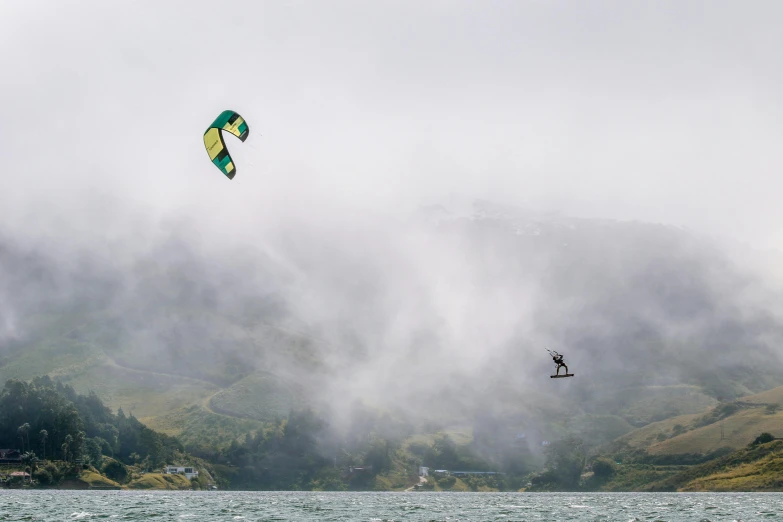 two people standing on the water flying a kite