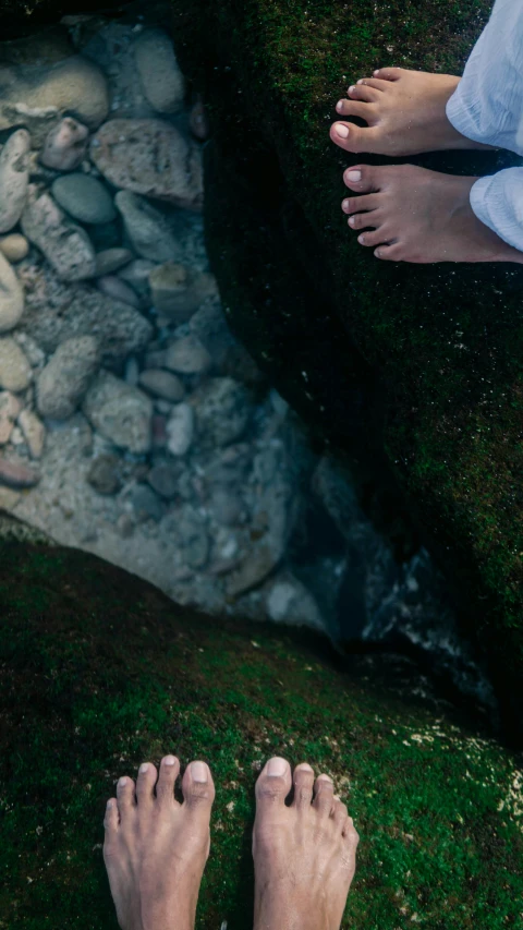 one person has bare feet and has their other foot up above the grass