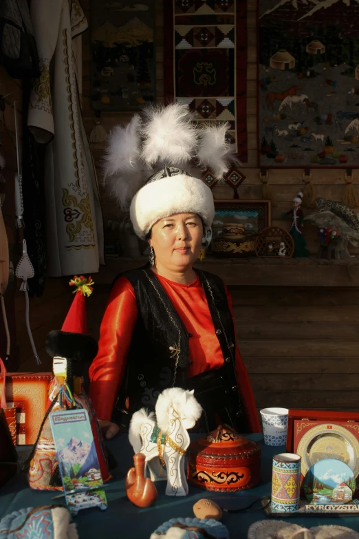 a woman sitting at a table with dishes and other things on it