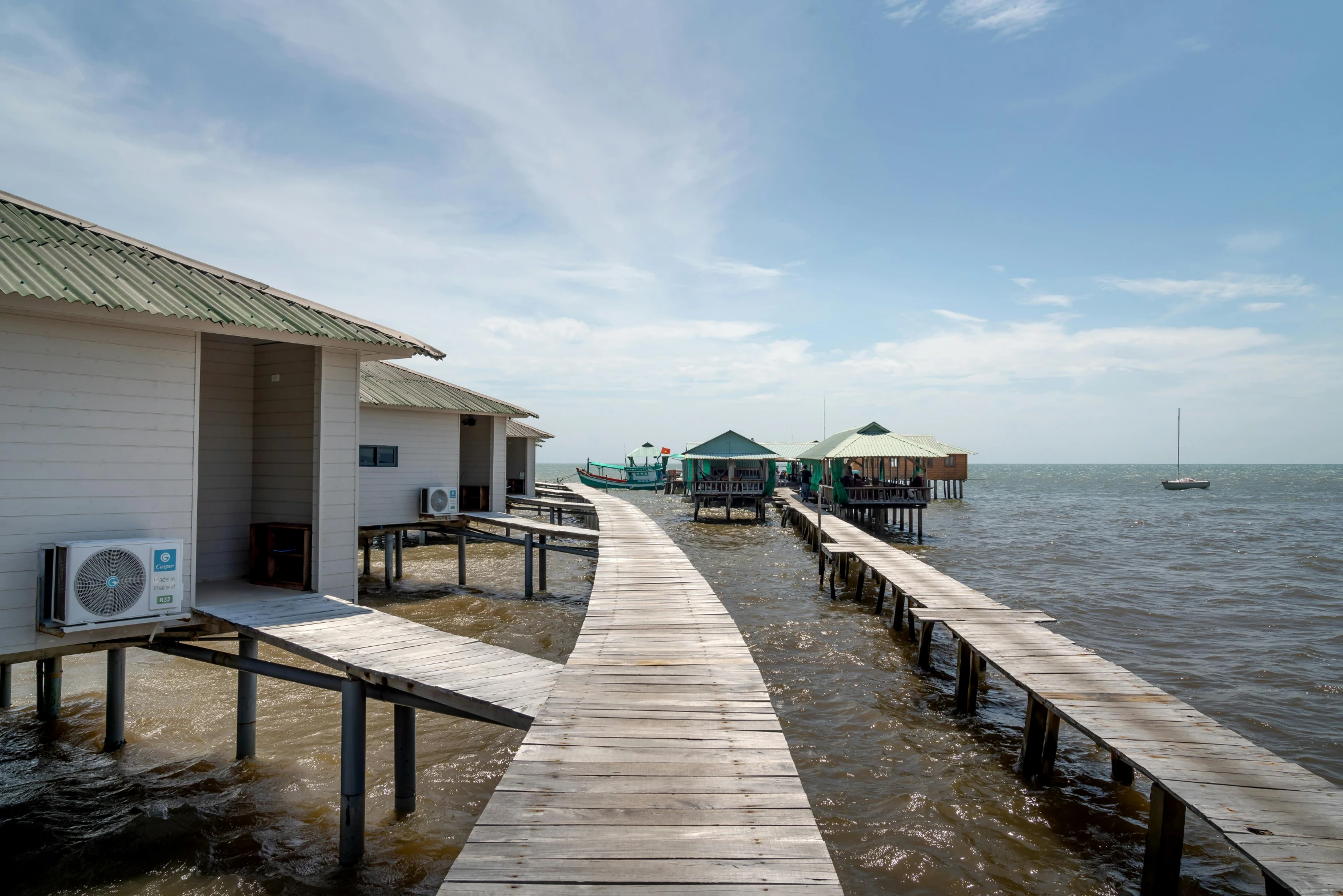 wooden dock with chairs and other buildings by the water