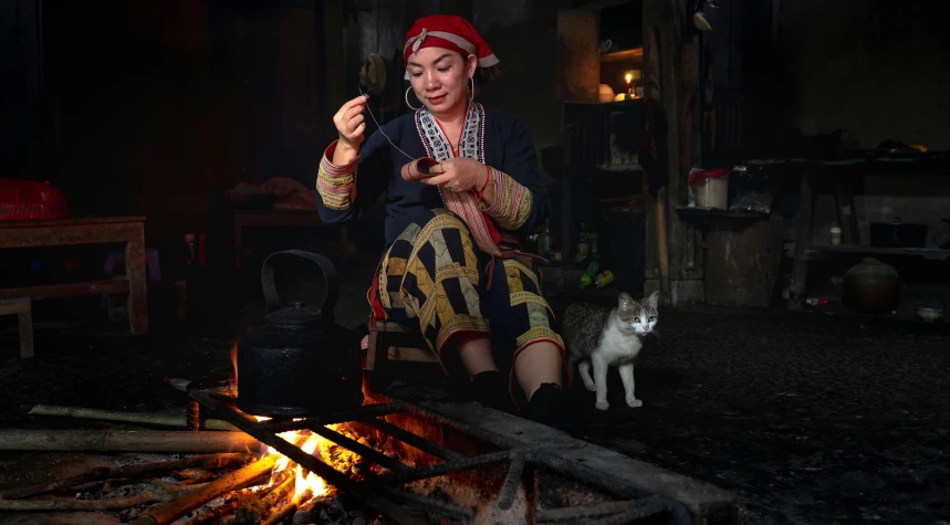 a woman standing in front of an open fire pit