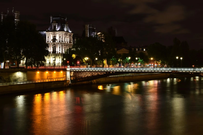 the city at night is lit up and reflecting on the water