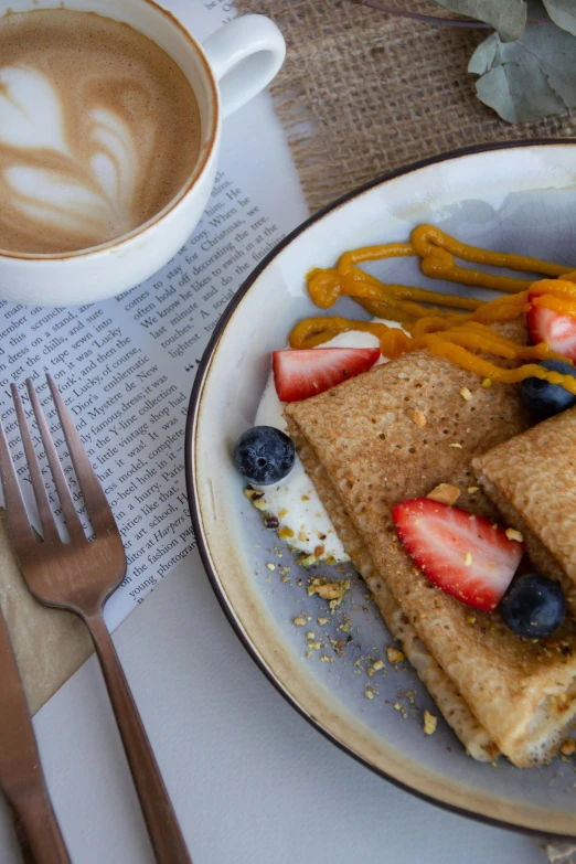 a dessert with strawberries, fruit, and syrup