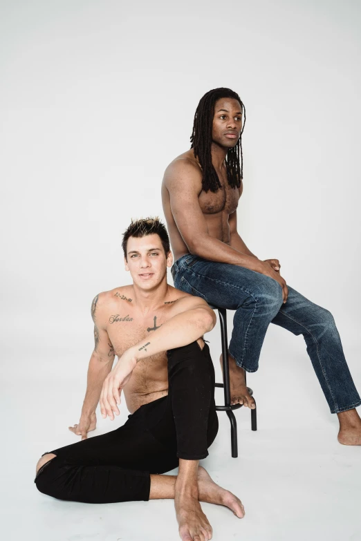 two shirtless men pose for the camera
