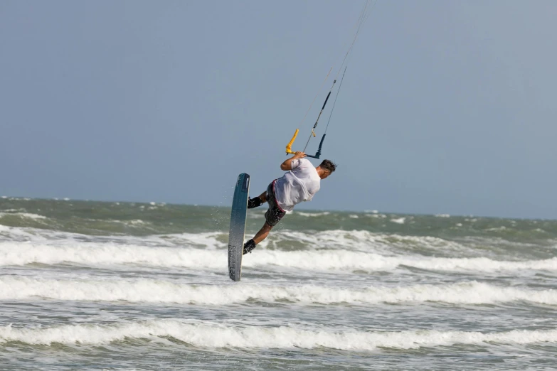 a man water skiing in the ocean holding onto a kite board