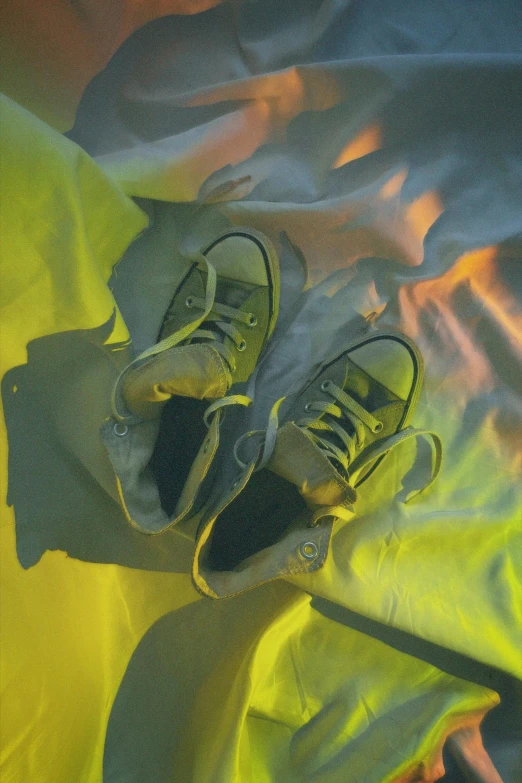 two tennis shoes are laying on a sheet